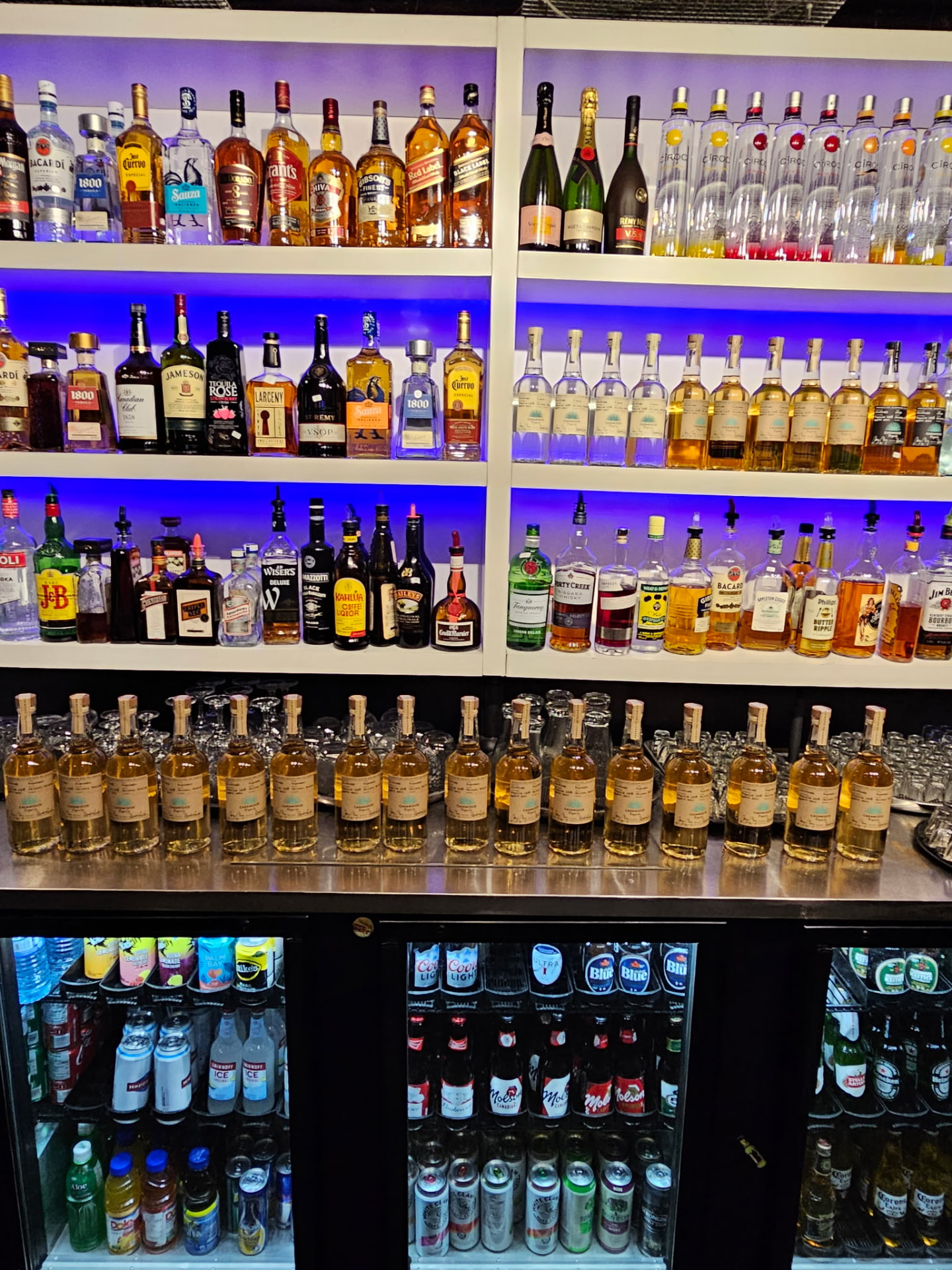 Backlit liquor bottles lined up behind the bar at Boulevard Billiards